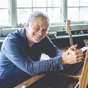 Composer-pianist Bruce Wolosoff sitting at a piano