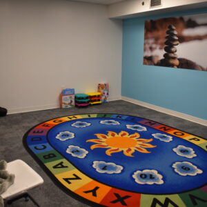 Movement treatment room with a colorful rug on the floor and movement equipment in the background